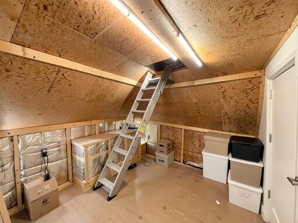 Freshly boarded loft storage space with loft ladder and strip lighting